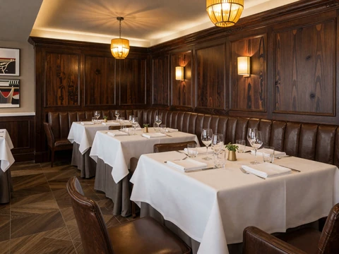 Luxury Highland Park Dallas steakhouse dining room with walnut paneling and white linen tablecloths